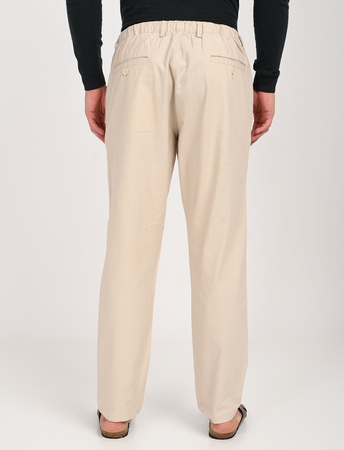Back view of men's cream linen blend trousers with elastic waist and pockets, perfect for casual and college wear.