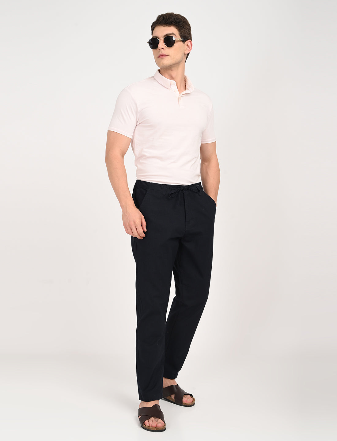 Model wearing Navy Blue Linen Blend Trousers with a light pink polo and sunglasses, showcasing casual summer style.